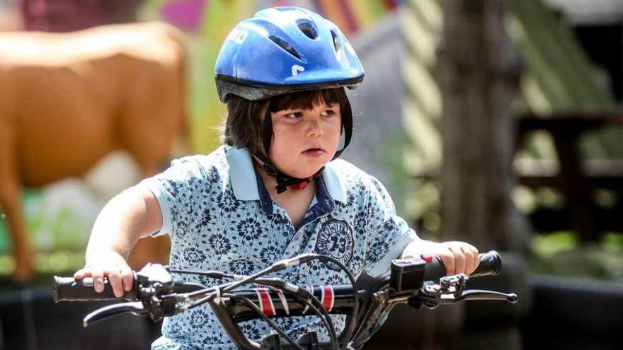 Una chiquilla sobre un quad infantil en el recinto ferial gijonés.