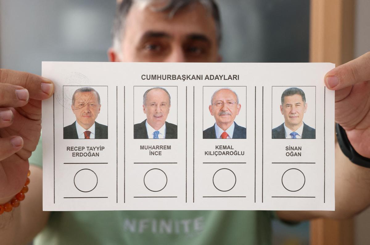 Una persona sostiene la papeleta con la imagen de los candidatos durante las elecciones presidenciales y parlamentarias turcas en un colegio electoral en Ankara, Turquía.