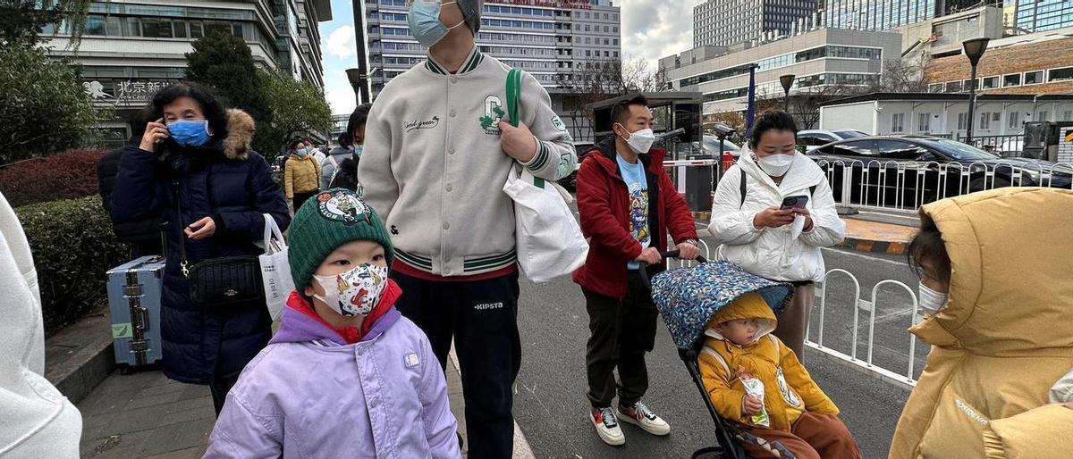Niños y familiares frente al Hospital Infantil de Pekín.