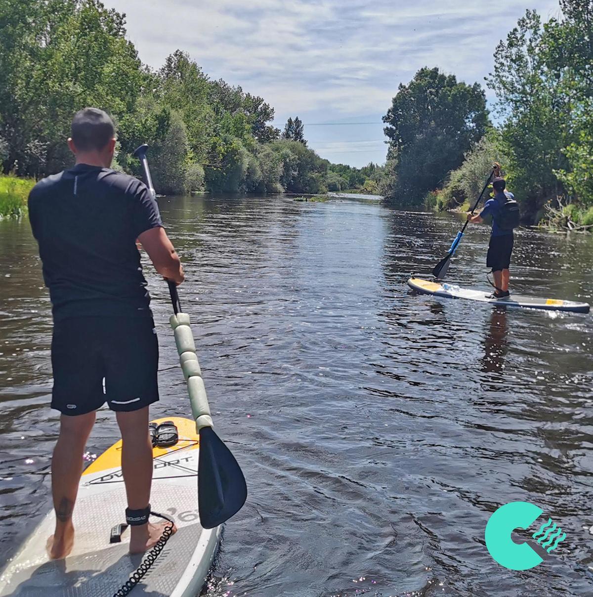 Paddle. Dos viajeros practican deportes de aventura.