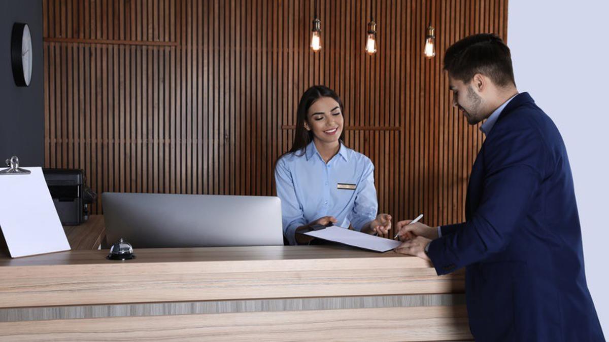 Archivo - Un turista se registra a la entrada en un hotel