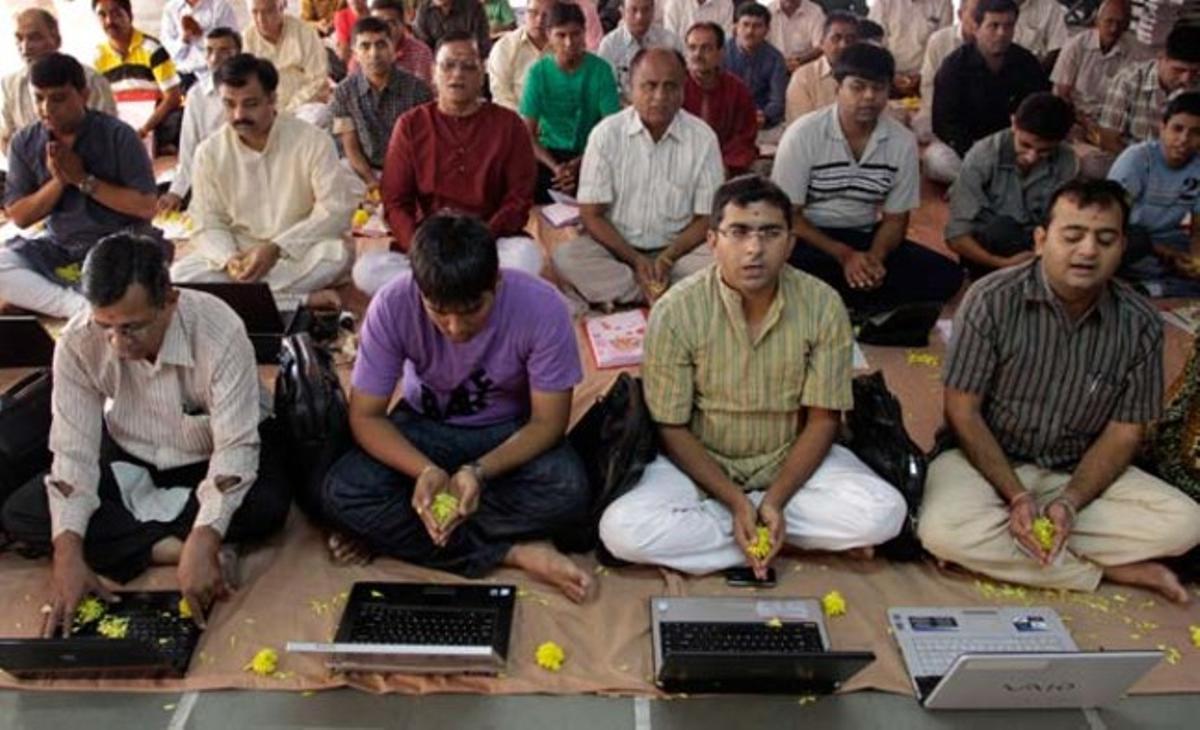 Un grup de persones resa davant els seus ordinadors portàtils al festival hindú de les llums, a Ahmadabad. Un grup de persones resa davant els seus ordinadors portàtils al festival hindú de les llums, a Ahmadabad.