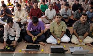 Un grup de persones resa davant els seus ordinadors portàtils al festival hindú de les llums, a Ahmadabad.
