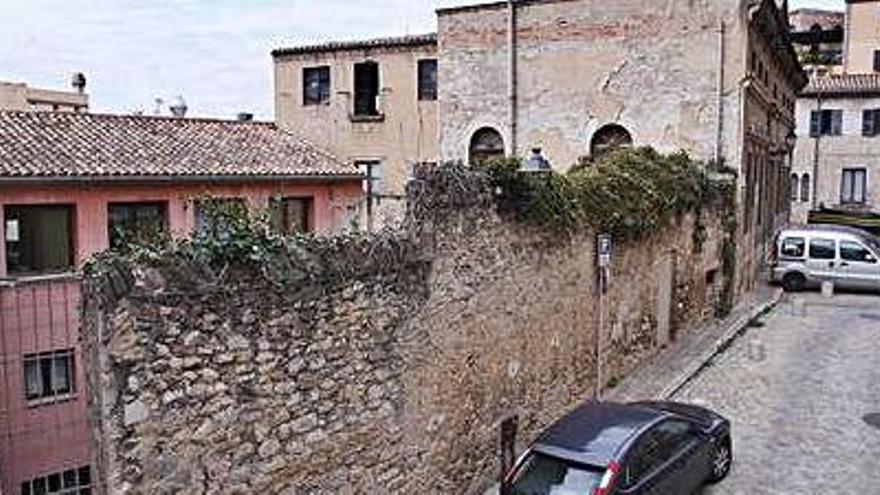 Exterior del pati, protegit per un mur i una porta metàl·lica.