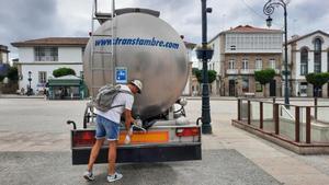 Un turista rellena una botella de agua, ayer, en la cisterna de la plaza Hermanos García Naveira.