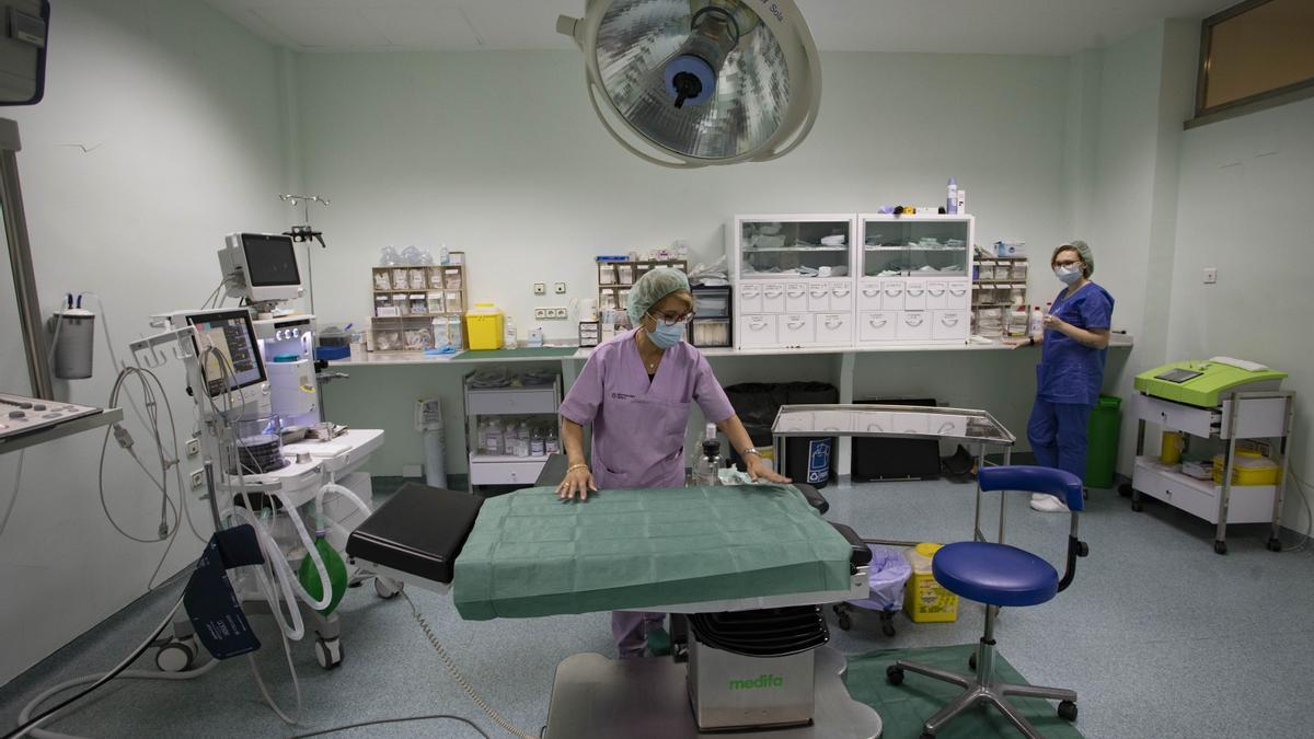 Dos sanitarias preparan el quirófano en una clínica.