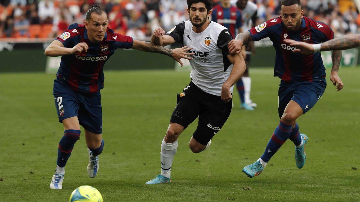 Guedes disputa un balón con Son y Vezo.