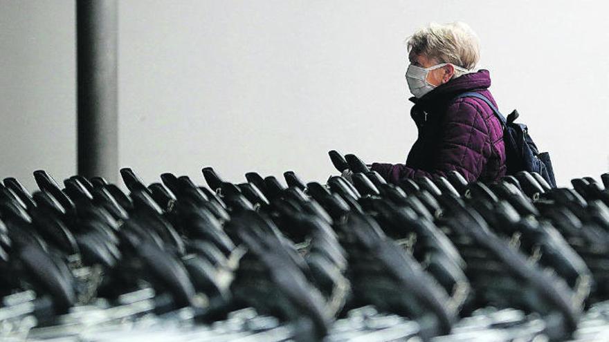 Una mujer, en Praga, va a la compra con mascarilla.