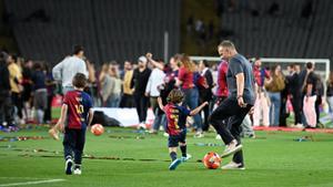 Flick juega con su nieto en Montjuïc tras celebrar el triplete doméstico.