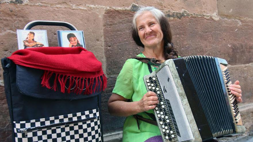 Taisia sentada junto a su acordeón y algunos de sus discos.