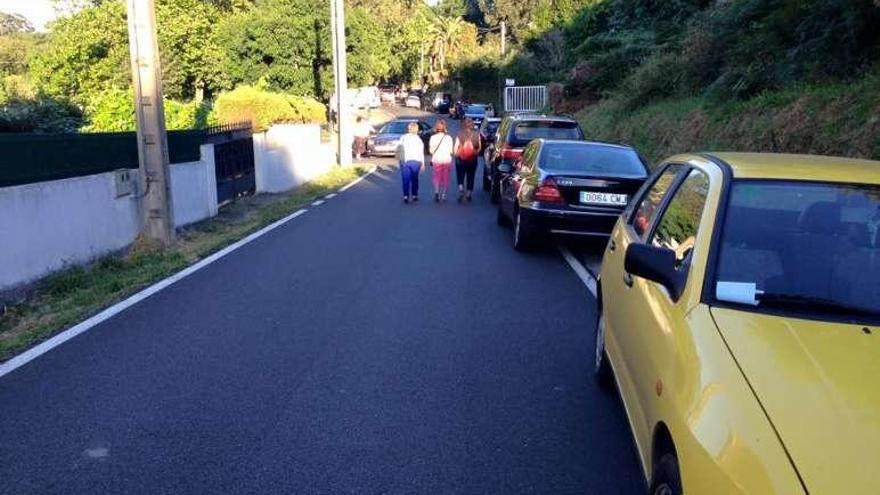 Vía en Mera atestada de coches por las fiestas de julio de 2016.