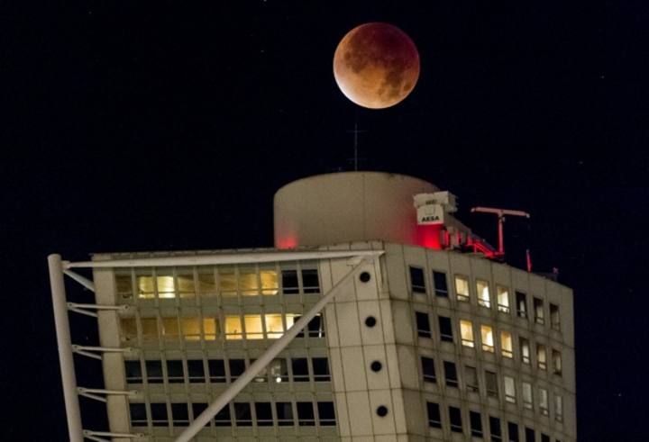 The supermoon appears above the Turning Torso building during a total lunar eclipse in Malmo, south of Sweden