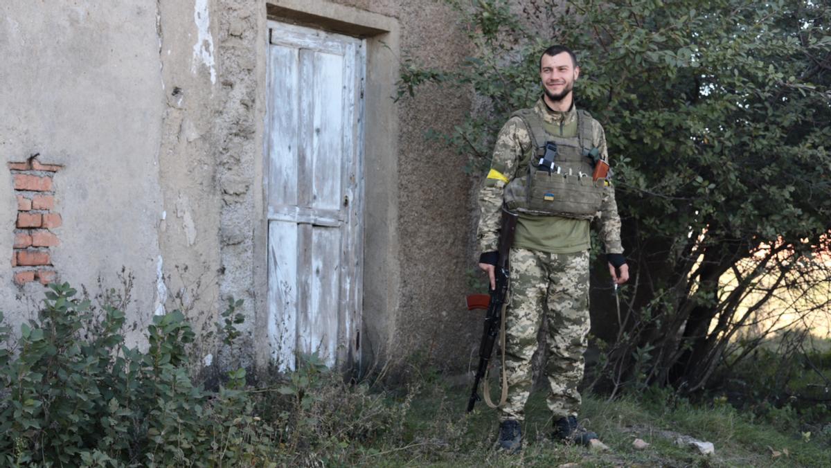 El soldado ucraniano Serhiy Vazmniy pasa frente a un edificio con una cruz en la puerta en la provincia de Jersón.
