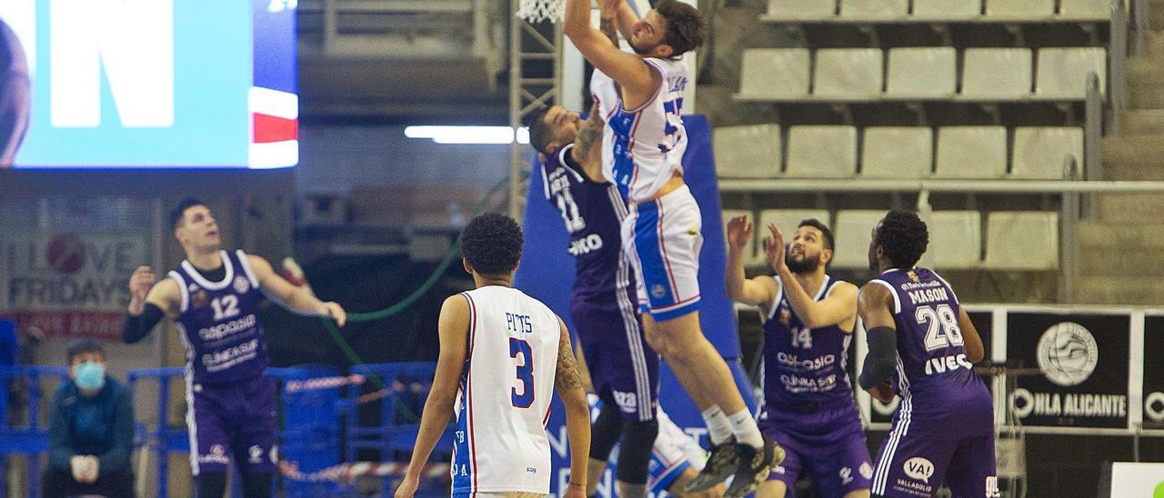 Alejandro Galán bajo el aro con los jugadores del Valladolid, ante la presencia de Pitts. |