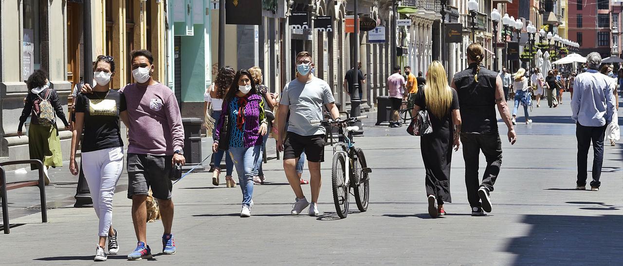 Varias personas pasean con mascarilla por la calle Triana de Las Palmas de Gran Canaria. | | ANDRÉS CRUZ