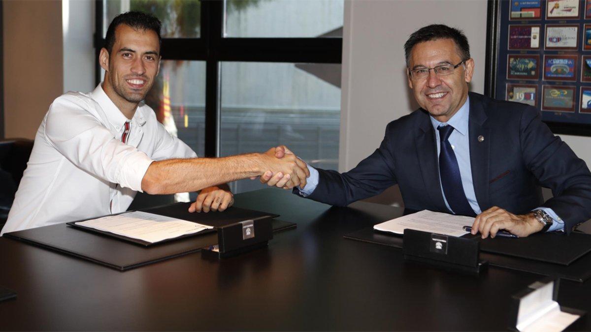 Sergio Busquets y el presidente Josep Maria Bartomeu tras la renovación de contrato del mediocentro del FC Barcelona