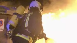 Arden tres coches aparcados en un descampado junto a la estación de autobuses