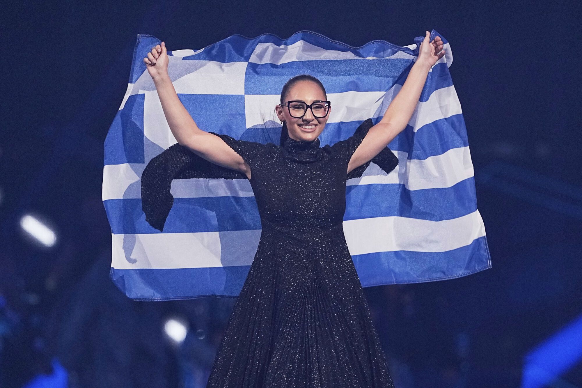 Klavdia from Greece walks onstage hold up her countries flag during the Grand Final of the 69th Eurovision Song Contest, in Basel, Switzerland, Saturday, May 17, 2025. (AP Photo/Martin Meissner)