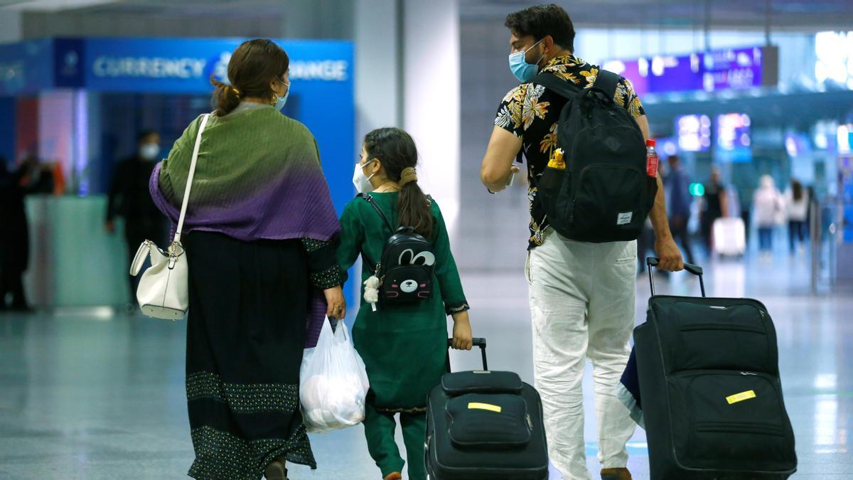 Una familia camina con sus maletas a su llegada al aeropuerto de Fráncfort, tras ser evacuada de Kabul.