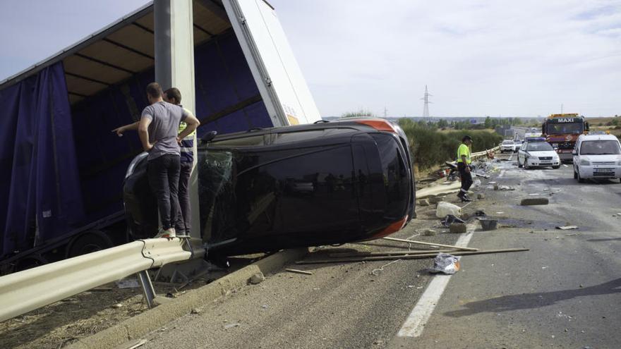 Uno de los vehículos que transportaba el camión atrapado contra un poste.