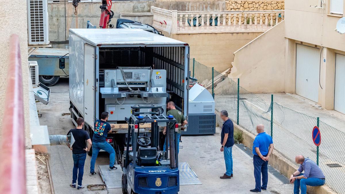 La Policía carga en un camión una de las impresoras intervenidas a la red de billetes falsos en una nave de La Nucia.