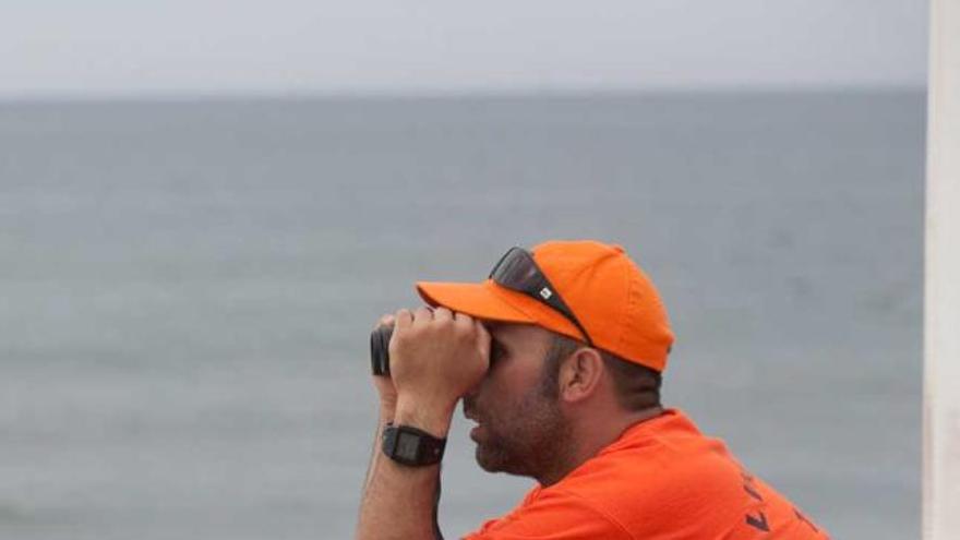 Dos socorristas, vigilando la playa de Salinas al inicio de la temporada.