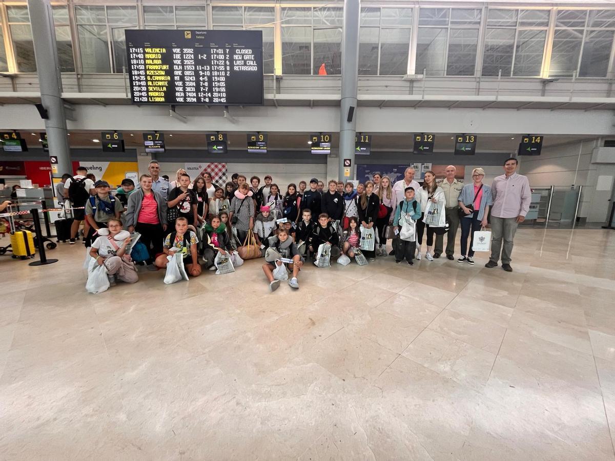 El grupo de niños, con los coordinadores del campamento y autoridades, en el Aeropuerto de Asturias, antes de partir.