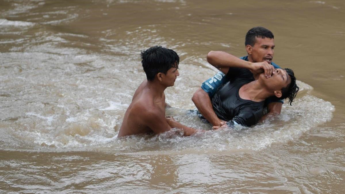 Migrantes hondureños tratan de cruzar el río Goascarán para ingresar en El Salvador de manera clandestina.