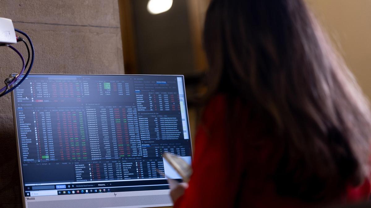 Una inversora mira la evolución de las cotizaciones en la Bolsa