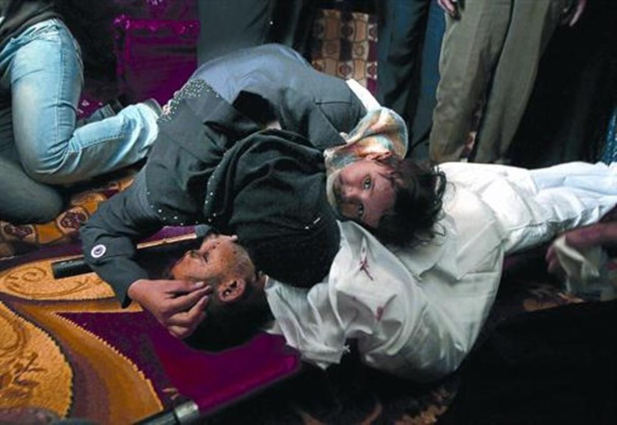 Familiars d’una víctima ploren sobre el seu cos a Khan Iunis (sud de Gaza).