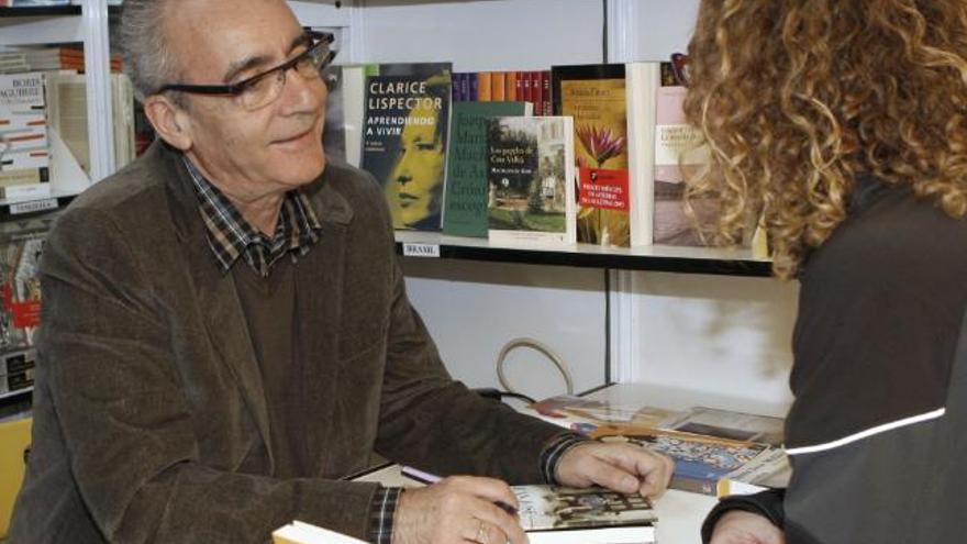 El escritor Juan José Millás firma ejemplares de su obra en una de las casetas que la 67 edición de la Feria del Libro de Madrid tiene instaladas en el parque de El Retiro, dedicada en esta ocasión a la literatura latinoamericana.