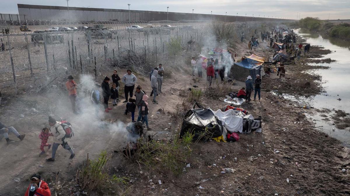 Migrantes acampan a lo largo de la orilla del río Grande mientras esperan entregarse a las autoridades de inmigración en El Paso, Texas, EE.UU