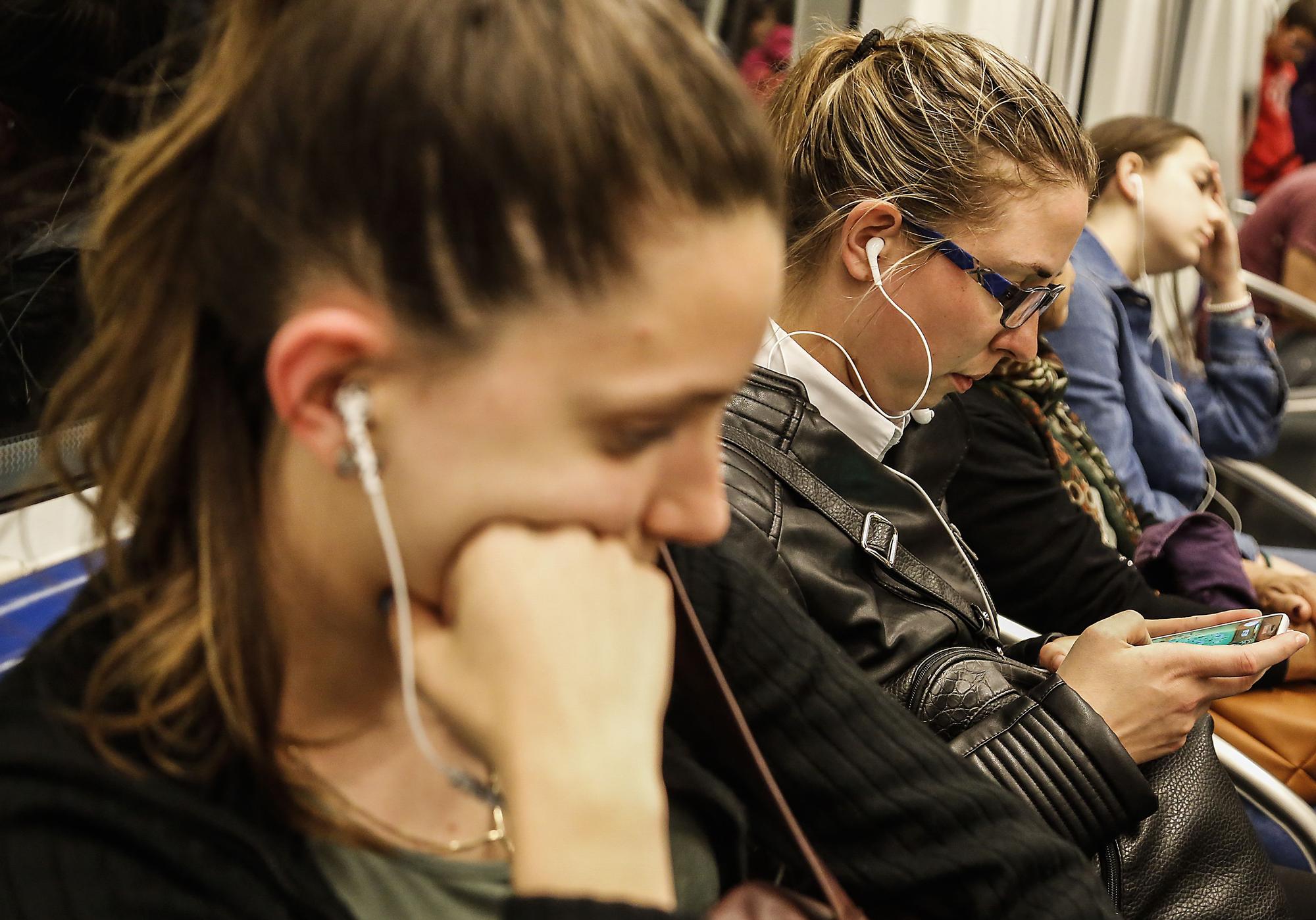 Personas con auriculares en el metro de Barcelona, en una imagen de archivo.
