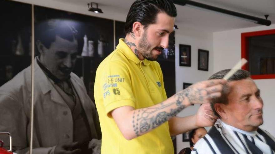 Eloy Entenza esta semana en su barbería con un cliente. // Gonzalo Núñez