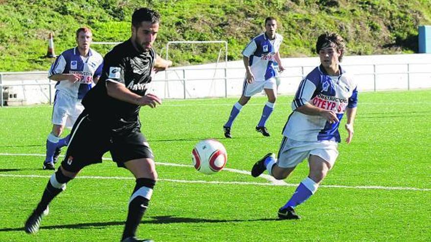 El jugador del Oviedo B Pascual despeja el balón ante la presión del arlequinado Borja Argüelles.