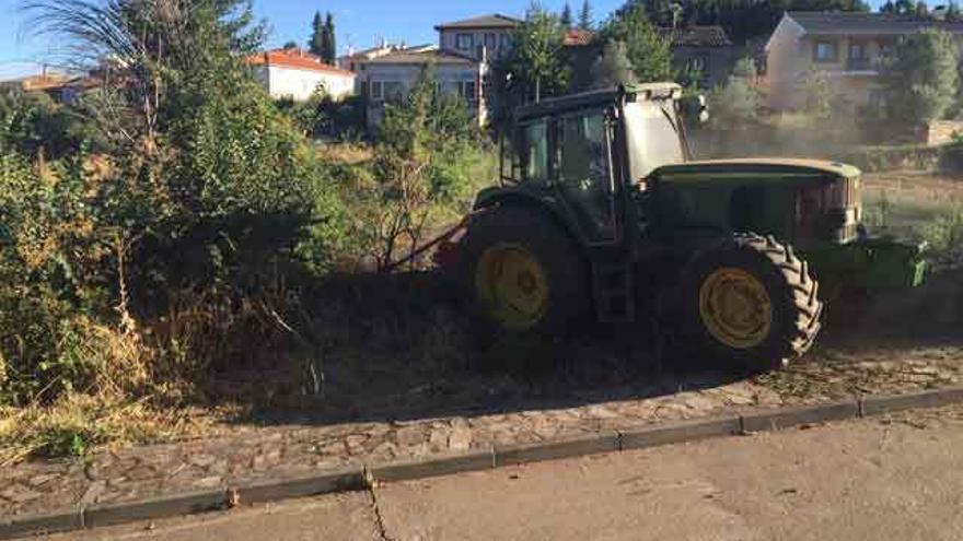 Un vehículo del Ayuntamiento limpiando un solar en Trabazos.