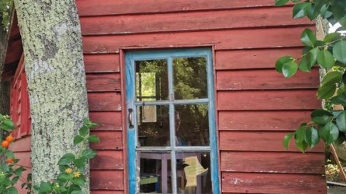 Casita de madera para sus nietas, en medio de los árboles del jardín.