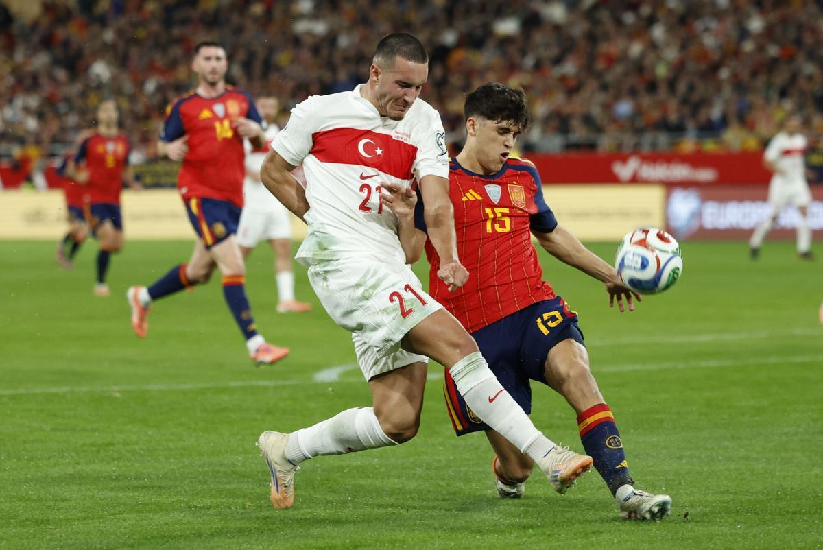SEVILLA, 18/11/2025.- El delantero de Turquía, Deniz Gül (i), disputa el balón ante el defensa de la selección española, Marc Cubarsí, durante el encuentro correspondiente a la fase de clasificación para el Mundial 2026 que disputan hoy martes España y Turquía en el estadio de La Cartuja, en Sevilla. EFE / Julio Muñoz.