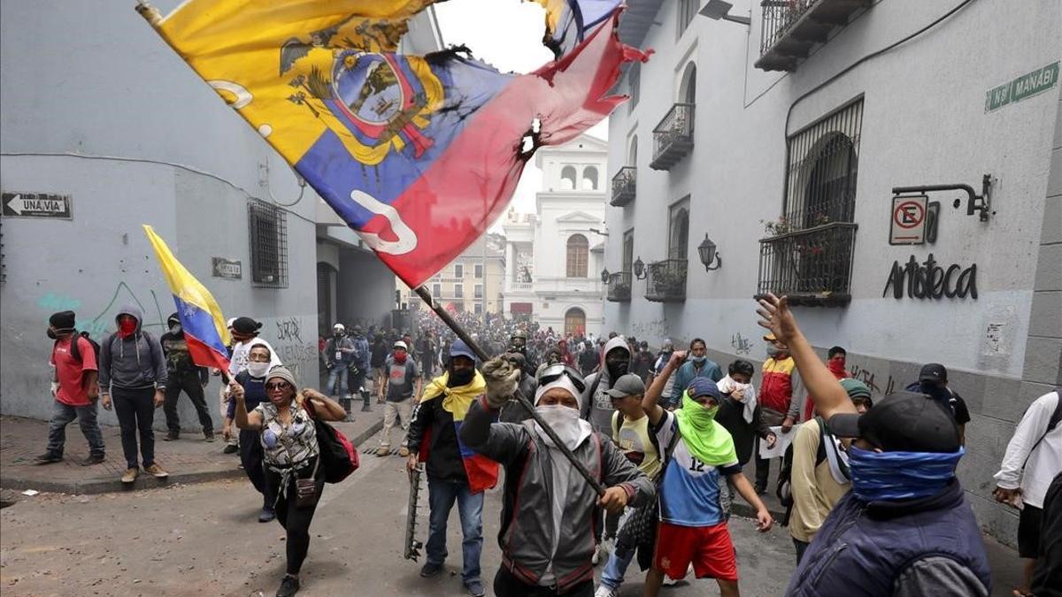 Manifestantes protestan contra el presidente Lenin Moreno y sus políticas económicas durante una marcha en Quito.