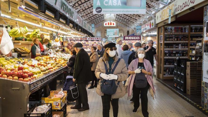 Clientes del Mercat Central con mascarilla, con uso de guantes entre vendedores y clientes.