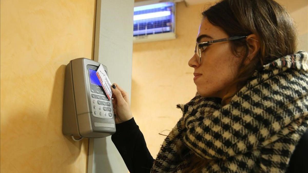 Una empleada ficha a la entrada de su trabajo