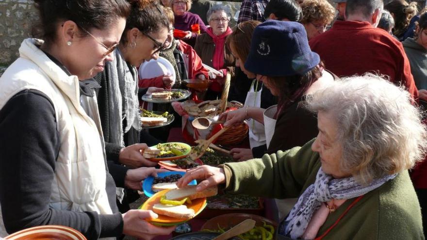 Voluntarios repartiendo la típica comida de la fiesta de es Quarteró: arenques con verduras.