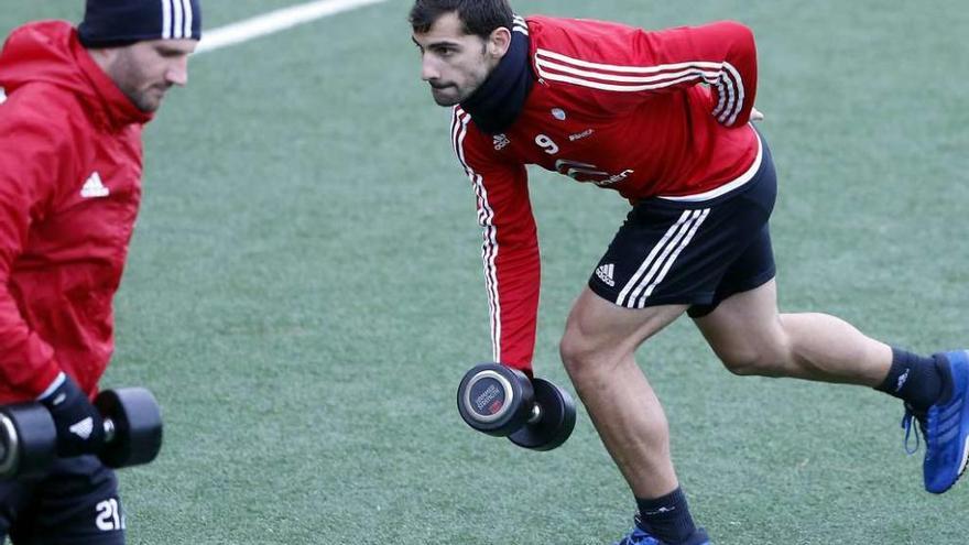 Jonny Castro, a la derecha, realiza un ejercicio con pesas junto a Carles Planas (izquierda) durante el entrenamiento matinal celebrado ayer por el Celta en A Madroa. // Marta G. Brea