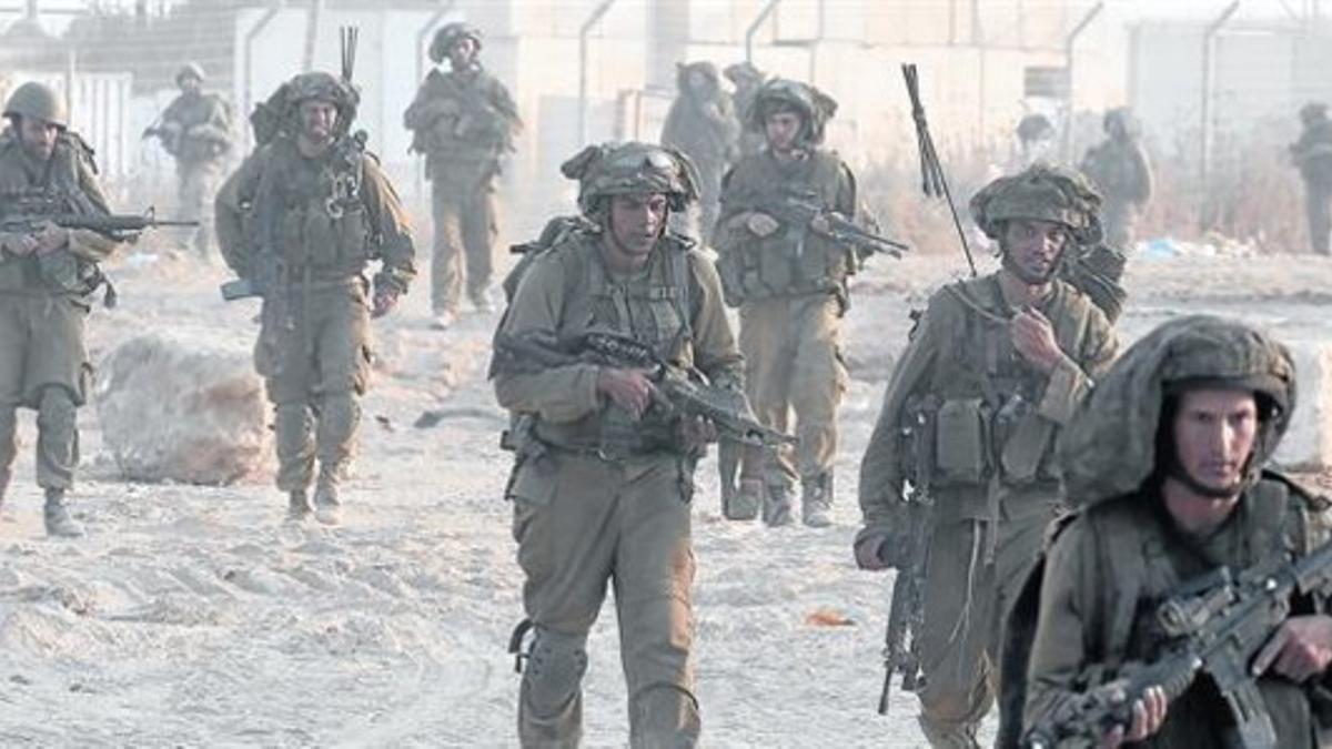 Soldados israelís regresan a Israel tras una incursión en el interior de la franja de Gaza, ayer.