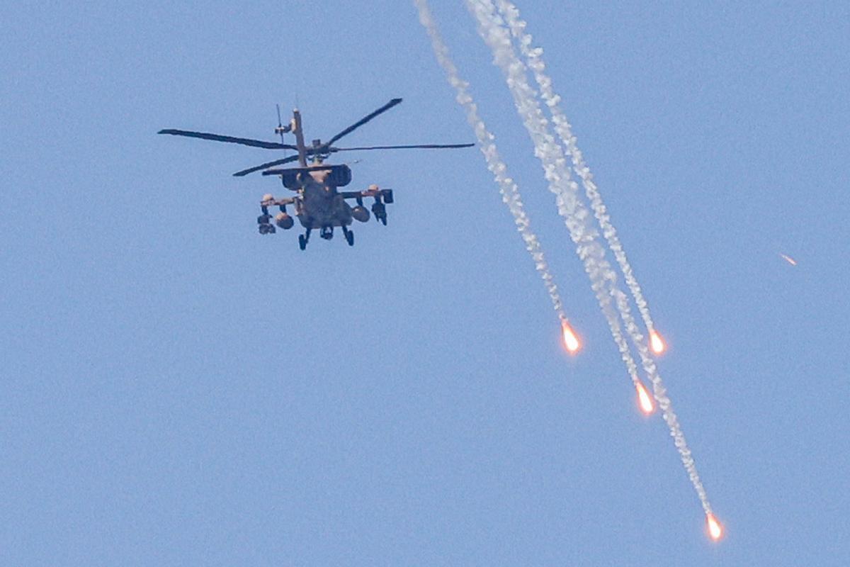 Un helicóptero de ataque Apache AH-64 del ejército israelí dispara bengalas mientras sobrevuela Ashkelon, en el sur de Israel