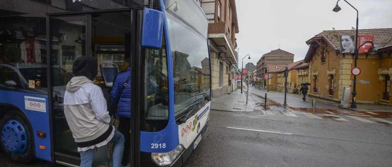 Un joven toma un autobús en la avenida Alcalde José Fernandín de Piedras Blancas.