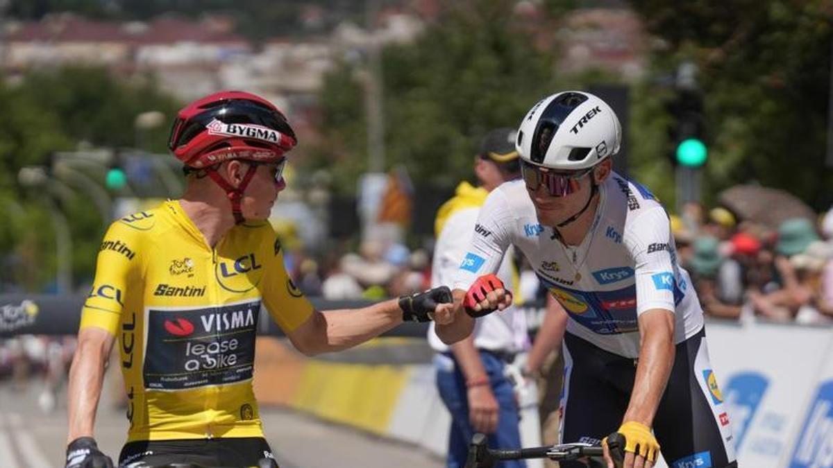 Ayuso, de blanco, choca su puño con Vingegaard, durante una etapa de este Tour