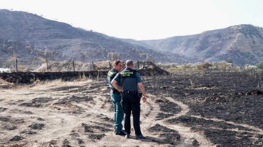 Dos agentes de la Guardia Civil, ayer, en una zona quemada de Nonaspe.