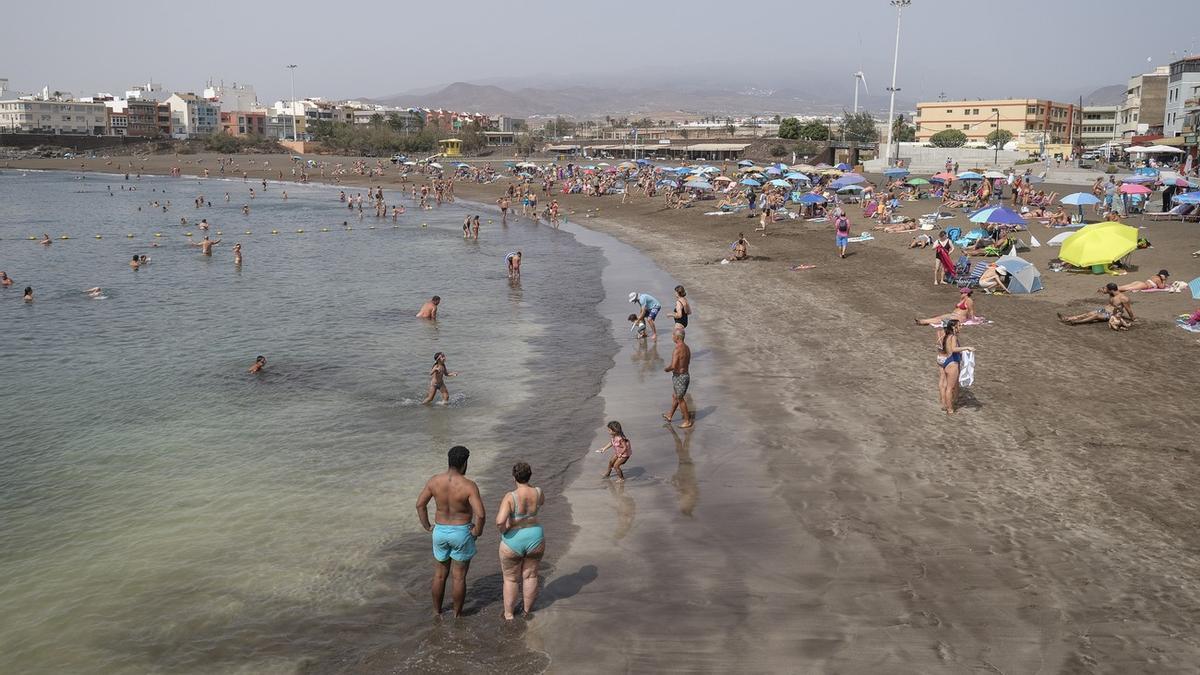 Los usarios se refrescan del calor en la playa en Melenara