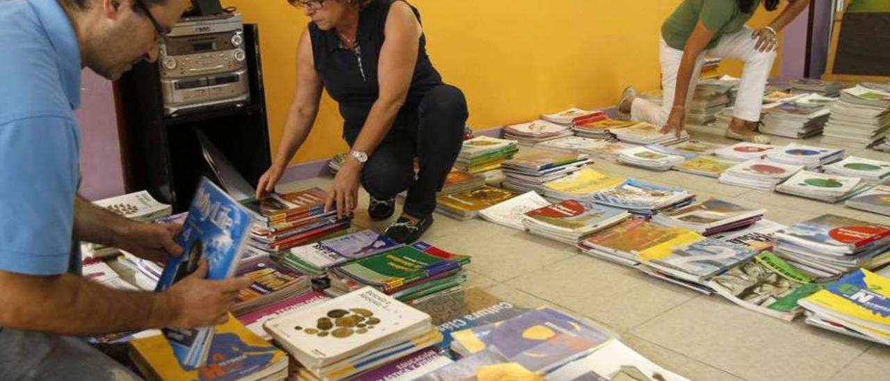 Voluntarios organizando los volúmenes en el banco de libros de Teis. // José Lores